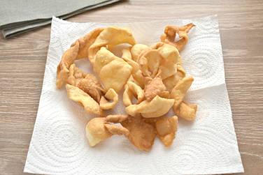 После жарки, чтобы удалить лишнее масло, хворост выкладываем на бумажные полотенца