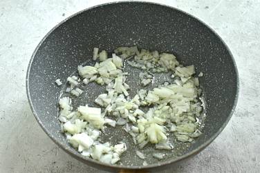 Нарезаем лук маленькими кусочками и отправляем его в сковороду, где уже разогрето растительное масло