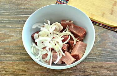Нарезку из свинины дополняем измельчённым полукольцами луком