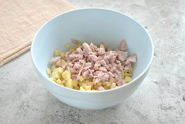 Копчёное куриное мясо (с любых частей птицы) нарезаем небольшими кусочками и переправляем к картофелю в миску