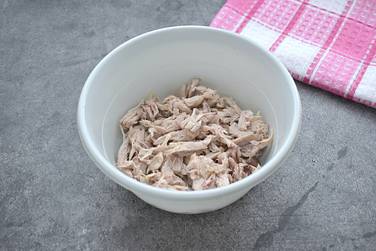 Отварное куриное мясо нарезаем брусочками, складываем в миску