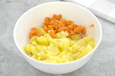 Отварной картофель и отварную морковку измельчаем кубиками, перекладываем к индейке