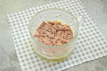 На картофельном слое располагаем кусочки консервированного тунца