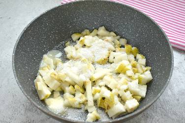 На горячую сковороду выкладываем кусочек сливочного масла, нарезку из груш и сахар