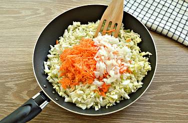 Капусту сразу же дополняем натёртой морковкой и измельчённым репчатым луком
