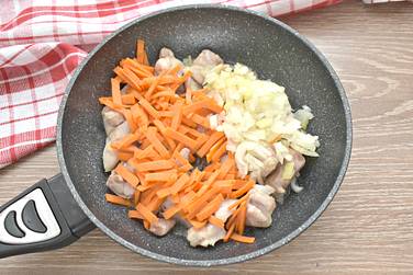 К куриным кусочкам добавляем нарезанный кубиком лук и морковку, измельчённую брусочками