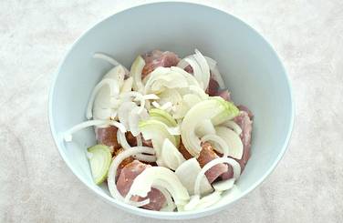 Лук нарезаем в форме полуколец, перекладываем к мясу