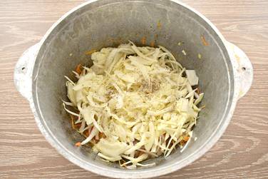 К мясу и овощам перекладываем нашинкованную капусту