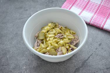 Маринованный огурец шинкуем соломкой, добавляем к курице