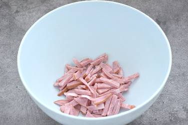 Ветчину нарезаем брусочками и складываем в глубокую миску