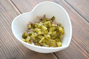 Солёный огурчик нарезаем кубиками, которые перекладываем к курице
