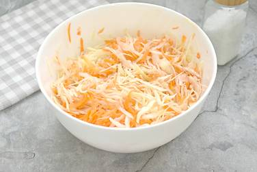 Капусту с морковью по вкусу солим и сразу перемешиваем, приминая руками