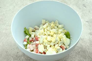 Варёные куриные яйца шинкуем кусочками и добавляем к ингредиентам в миску