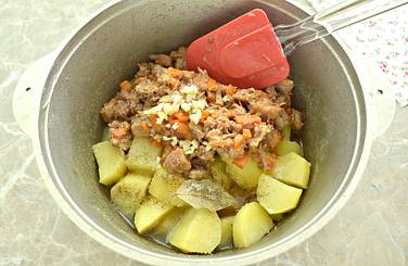 Со сковороды тушёнку с овощами перекладываем к картофелю, который уже практически готов
