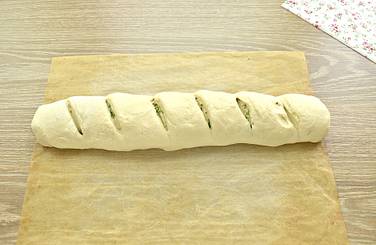 Пласт с чесночной начинкой сворачиваем в форме рулета
