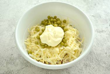 Для заправки в салат с копчёной курицей, горошком и сыром выкладываем майонез, по вкусу солим