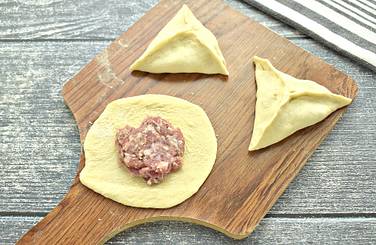 На заготовки из теста выкладываем примерно по столовой ложке мясной начинки