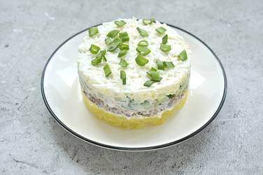 Слоёный салат с рыбными консервами, картошкой и свежим огурцом отправляем в холодильник на 20-30 минут
