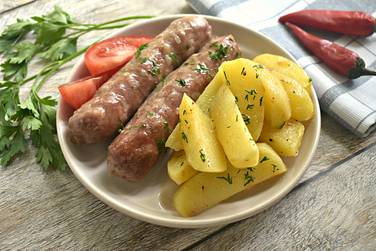 Купаты, запечённые с картошкой в духовке, перед подачей к столу посыпаем зеленью