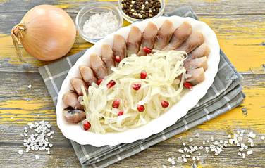 Аппетитный пикантный маринованный лук выкладываем на тарелку вместе с кусочками селёдки