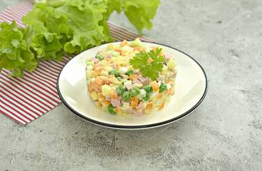 Вкусный Оливье со свежим горошком подаём к столу охлаждённым
