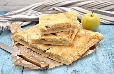 Вкусный и сочный пирог из слоёного теста с яблоками остужаем, нарезаем порциями и подаём к столу