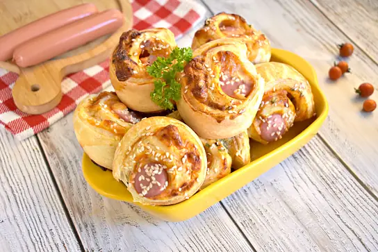 Рулетики из слоёного дрожжевого теста с сыром и сосисками