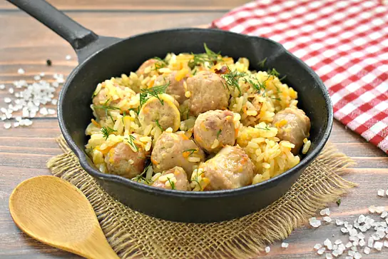 Рис с жареными колбасками и овощами на сковороде